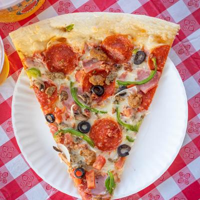 A slice of supreme pizza on a plate.