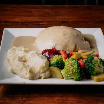 Turkey and white gravy served with vegetables and mashed potatoes.