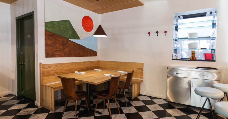 Interior, dining area and seating in a corner with mural on a wall