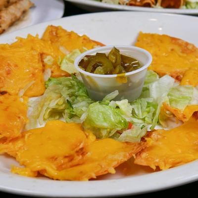 Cheesy nachos with lettuce and jalapenos.
