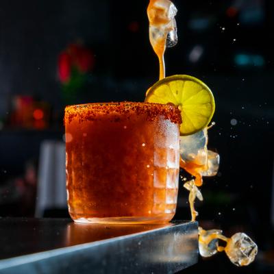 Michelada in a chili-rimmed glass with lime wheel garnish.