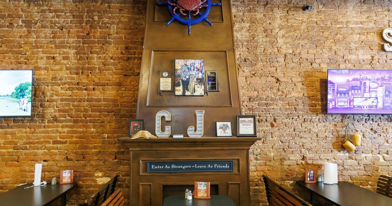 Interior dining area with tables and chairs along the brick wall