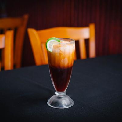 Thai iced tea with lime garnish.