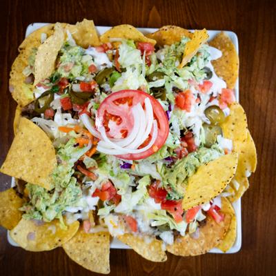 Nachos topped with guacamole and pico da gallo.