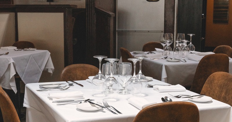 Restaurant interior, dining table set for four guests close-up