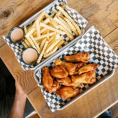 Wings with fries, served on a trays, top view.