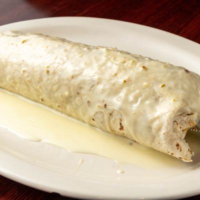 Burrito smothered in cheese sauce.