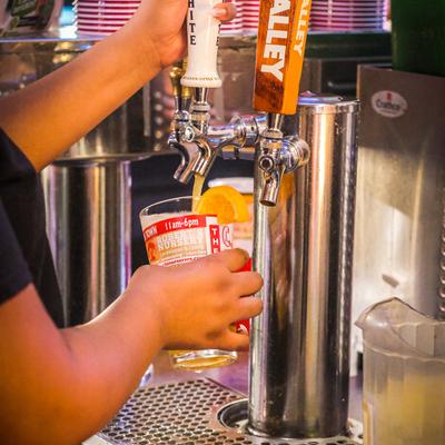 Hands pouring beer from the dispensary
