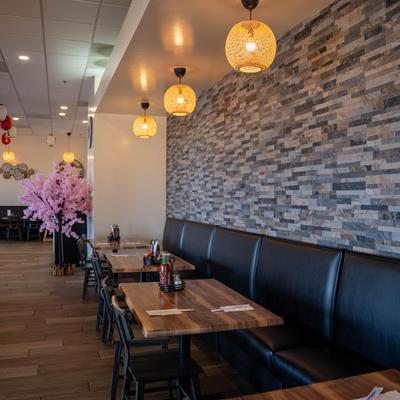 Interior with a leather banquette bench, tables, and pendant lights.