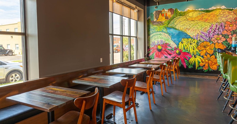 Interior, dining tables and seating, colorful mural on a wall
