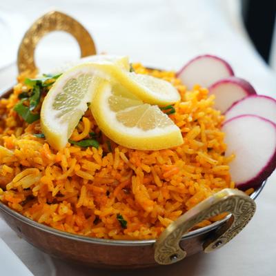 Chicken Biryani garnished with lemon and radish slices and herbs.