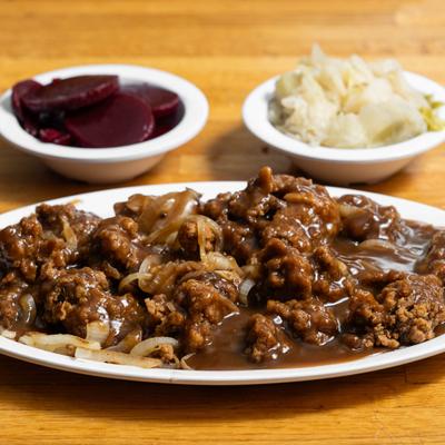 Fried beef with gravy and sides of cabbage and beets.
