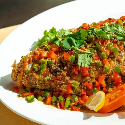 Red snapper topped with three flavor blended sauce, dish close up.