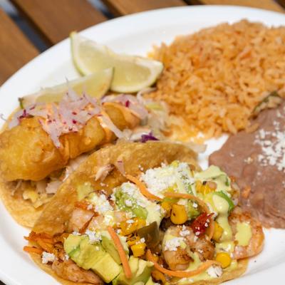 Beer battered fish taco, shrimp taco, rice, and refried beans.