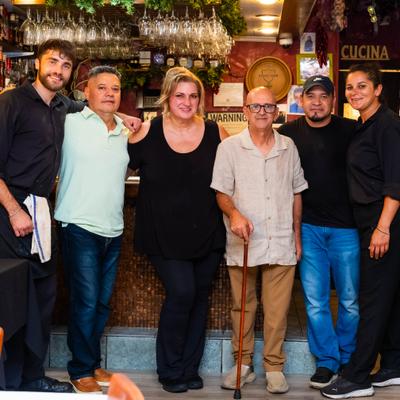 Six people posing together inside a restaurant.
