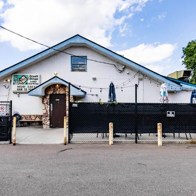 Steve O's Bar and Grill exterior with signage, outdoor seating, and umbrellas.