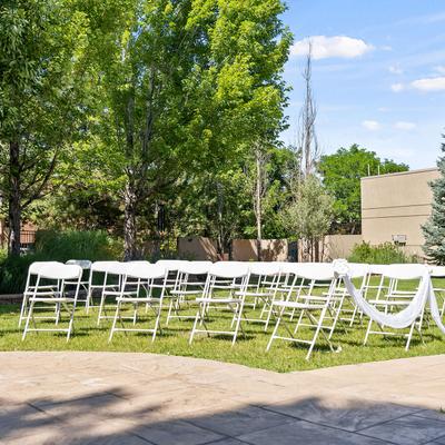 Arranged white chairs in grass near concrete path