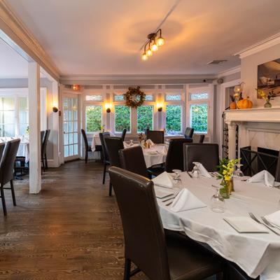 Dinong room with tables sert with white tablecloths, napkins and cutlery.