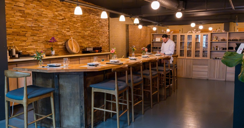 Interior, high wooden sushi table for six people, wooden stools