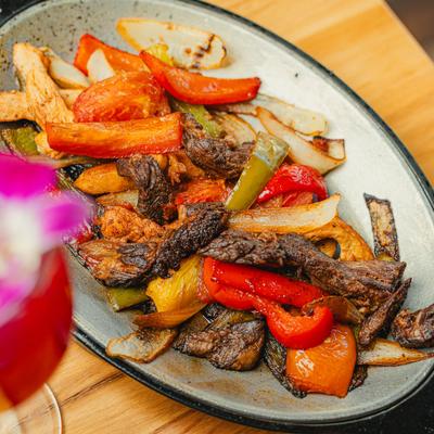 Mixed fajitas with steak, chicken, bell peppers, and onions.