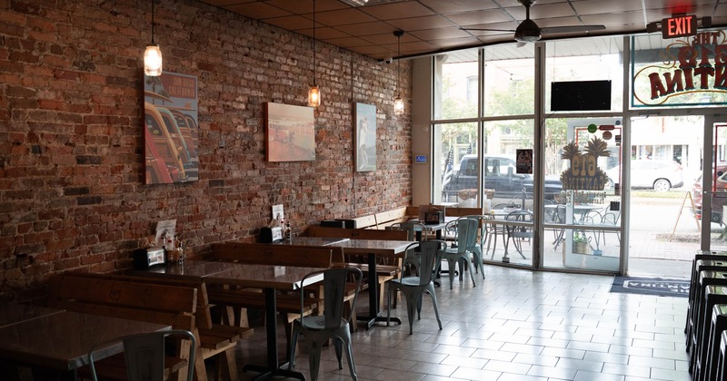 Interior, seating area, large shop window, restaurant entrance, posters on a brick wall