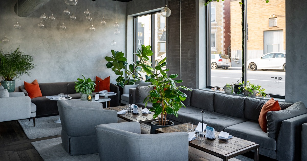 A modern and stylish lounge interior with comfortable gray sofas and armchairs