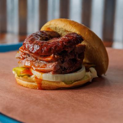 Brisket and sausage sandwich, with pickles, onions, mayo, and BBQ sauce.