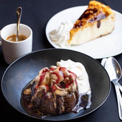 Lava cake, Creme Brulee cheesecake, and coffee on a dark tablecloth.