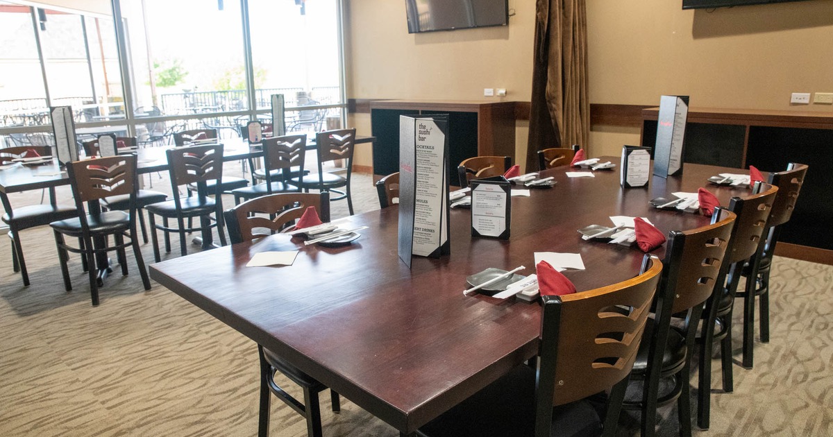 Interior, chairs and tables ready for guests, large shop window with patio view