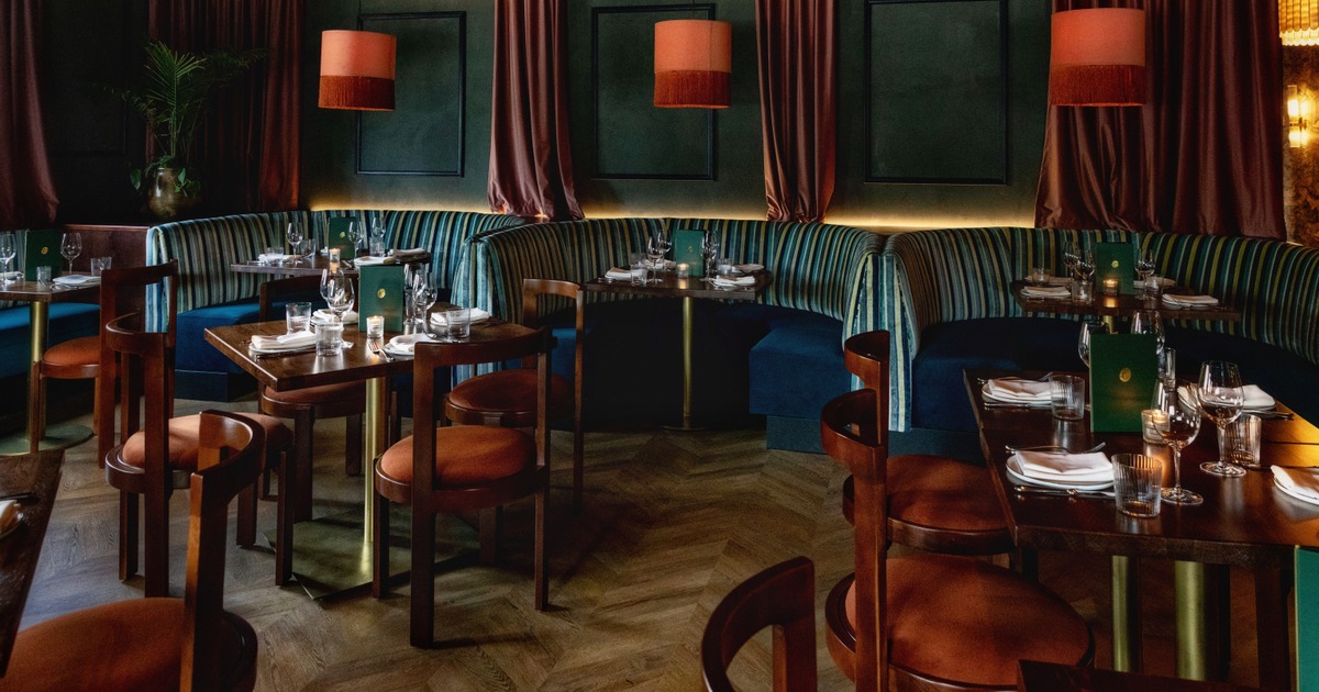 Elegant dining area with striped velvet booth seating and set wooden tables