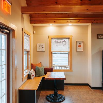 Corner table and a wooden bench with pillows.