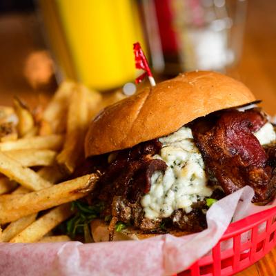 Bleu cheese and bacon burger, served with fries, close up.