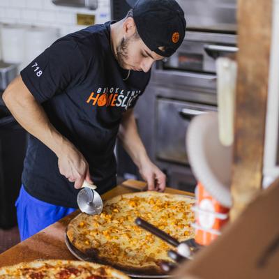 Chef slicing a pizza.