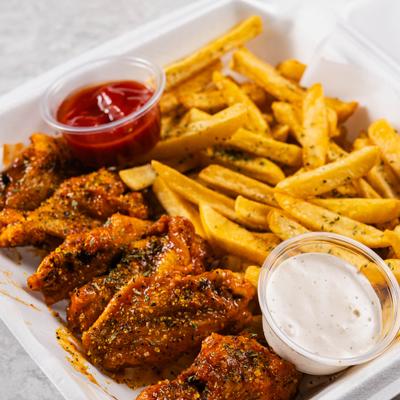 Seasoned chicken wings served with fries and dips.