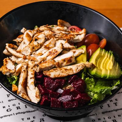 Grilled chicken salad with lettuce, cooked beets, avocado, and cherry tomatoes.