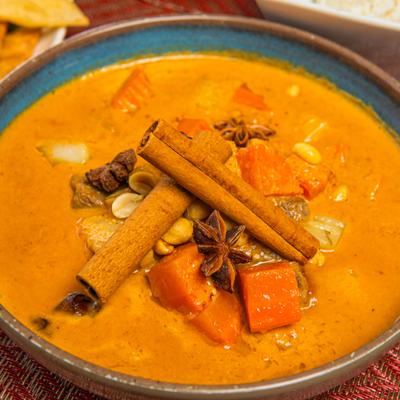 Massaman Curry garnished with cinnamon sticks, close-up.
