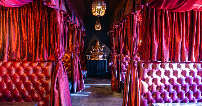Interior, dining area, seating booths separated with velvet curtains
