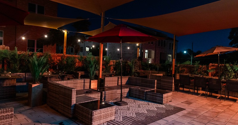 Outdoor patio featuring wicker sectional seating, a patterned outdoor rug and an umbrella
