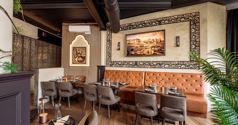 Modern and cozy interior dining area with dining tables set for guests