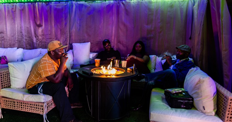 Outdoor lounge seating and a fire pit, guests enjoying their drinks