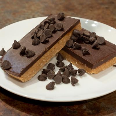 Chocolate dessert bars with chocolate chips on a round white plate.