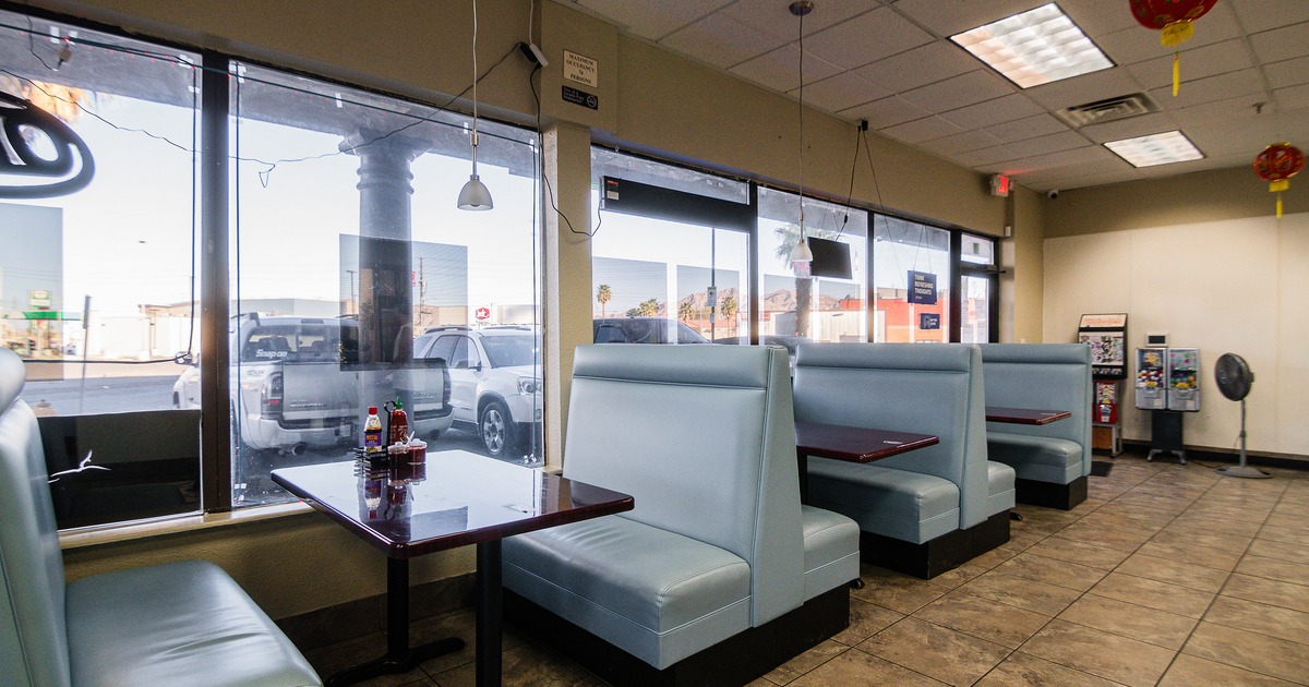 Interior dining area with upholstered booths lined up along windows