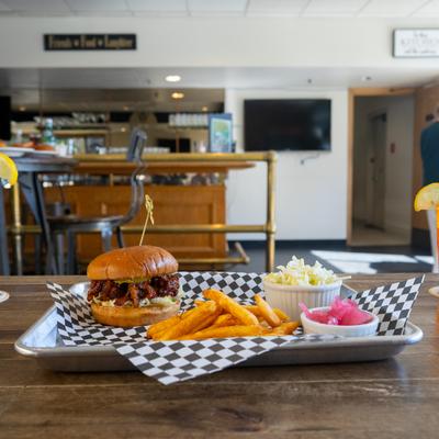 Pork BBQ sandwich with fries and salads on the side.