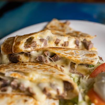 Pork quesadillas, with melted cheese, salad and sour cream