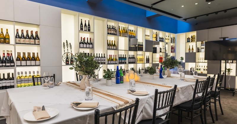 Cozy private dining room with set table and wine racks