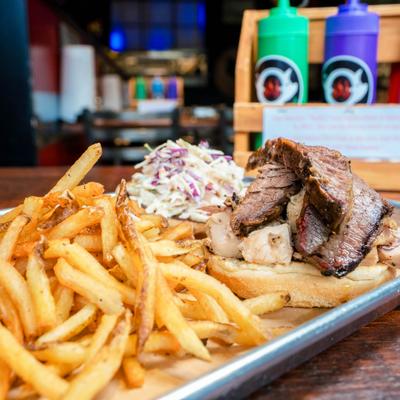 Smoko Loco sandwich with pulled pork, brisket, chicken, coleslaw and side of fries.