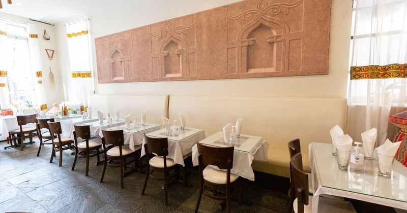 Cozy interior dining area with dining tables set for two guests