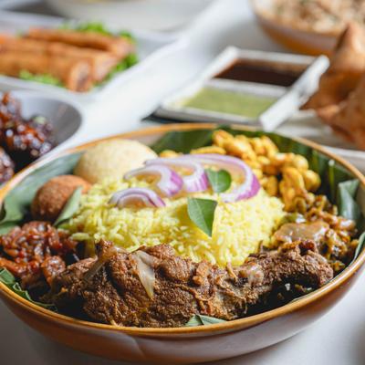 A dish of rice, meat , cashews, and vegetables