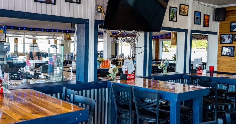 Interior, high seating area, wooden top tables with stools, various framed photos
