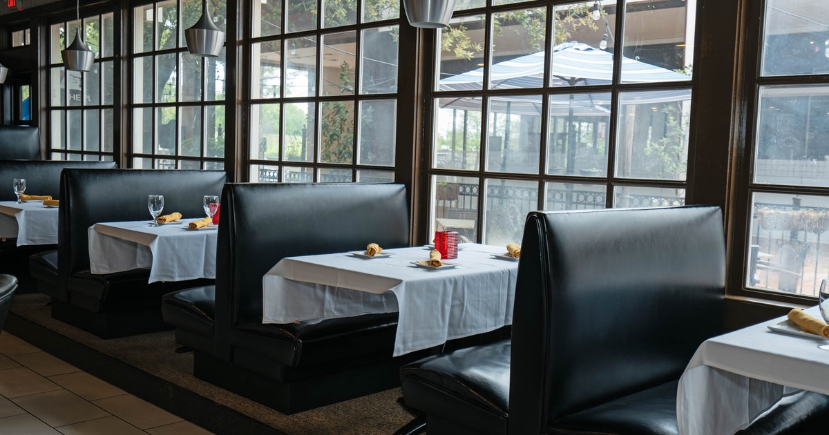 Restaurant interior with black leather booths and large windows